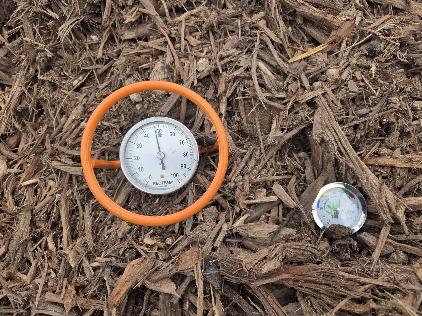 Temperature probes and monitoring equipment positioned in a covered compost windrow